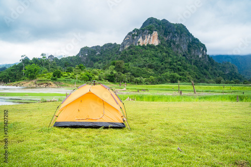 Landscape nature and mountains jungle and trees peaceful cloudy misty fog day, camping orange tent set on grass filed, holiday vacation travel destination outdoor adventure extreme hiking tracking