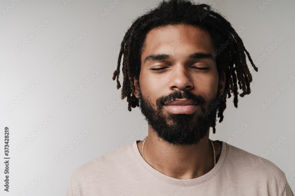 Guy posing isolated over grey wall background with eyes closed Guy posing isolated over grey wall background with eyes closed