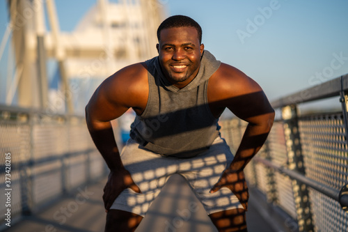 Young african-american man is exercising  on the bridge in the city. © djoronimo