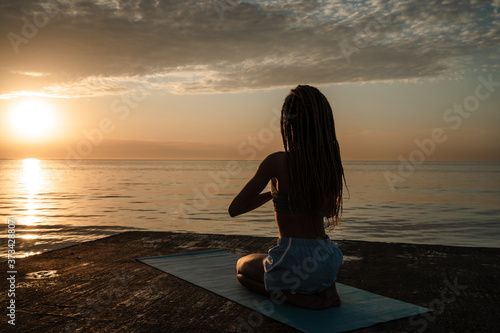 Image of calm african american girl meditating on concrete promenade