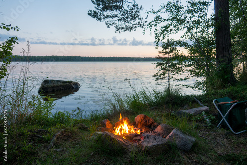 Fototapeta Naklejka Na Ścianę i Meble -  Lake view and campfire during sunset in Finland
