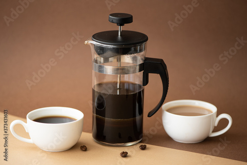 black coffee and coffee with milk in small cups on brown background