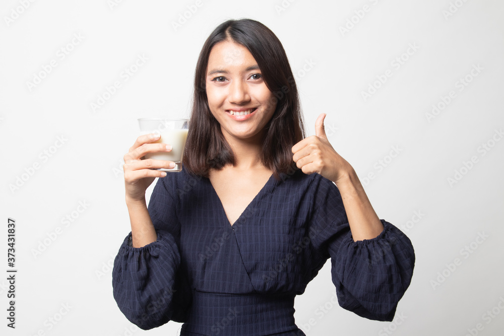 Healthy Asian woman drinking a glass of milk thumbs up. Healthy Asian woman drinking a glass of milk thumbs up.