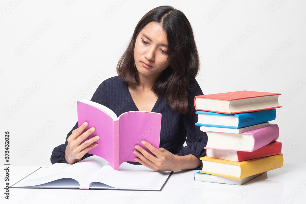 Young Asian woman read a book with books on table. Young Asian woman read a book with books on table.