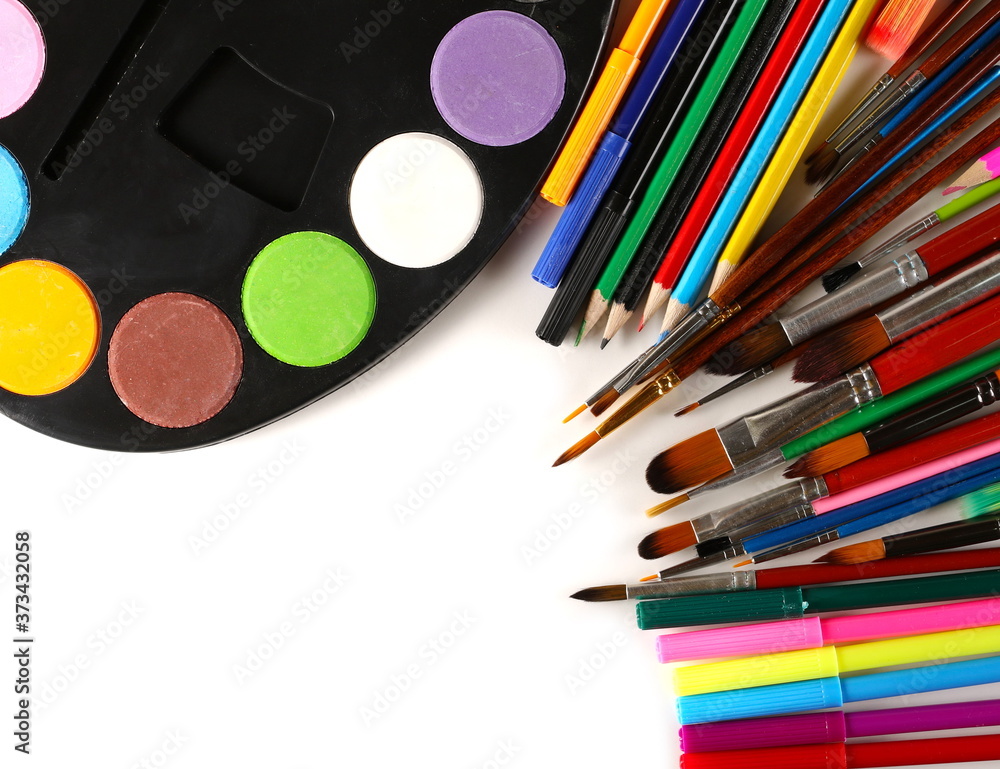 Naklejka premium Paint palette with watercolors, paintbrushes colorful pencils and felt markers pile, painting utensils isolated on white background
