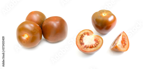 Dark red fresh tomatoes whole and slices isolated on white background.