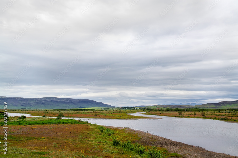 Beautiful scene of a river under the cloudy sky in Iceland