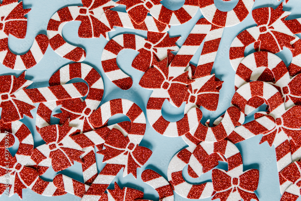 Naklejka premium Christmas composition. Christmas candy cane pattern on blue background. Happy holidays and new year concept.