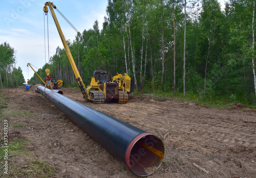 Pipelayer with side boom Installation of gas and crude oil pipes in ground. Construction of the gas pipes to new LNG plant. Soft focus