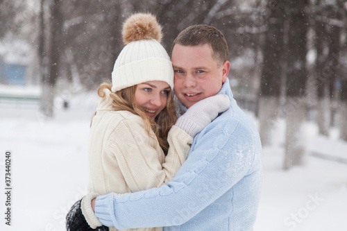 Young couple in knitted sweaters hugging in a winter park © Дэн Едрышов