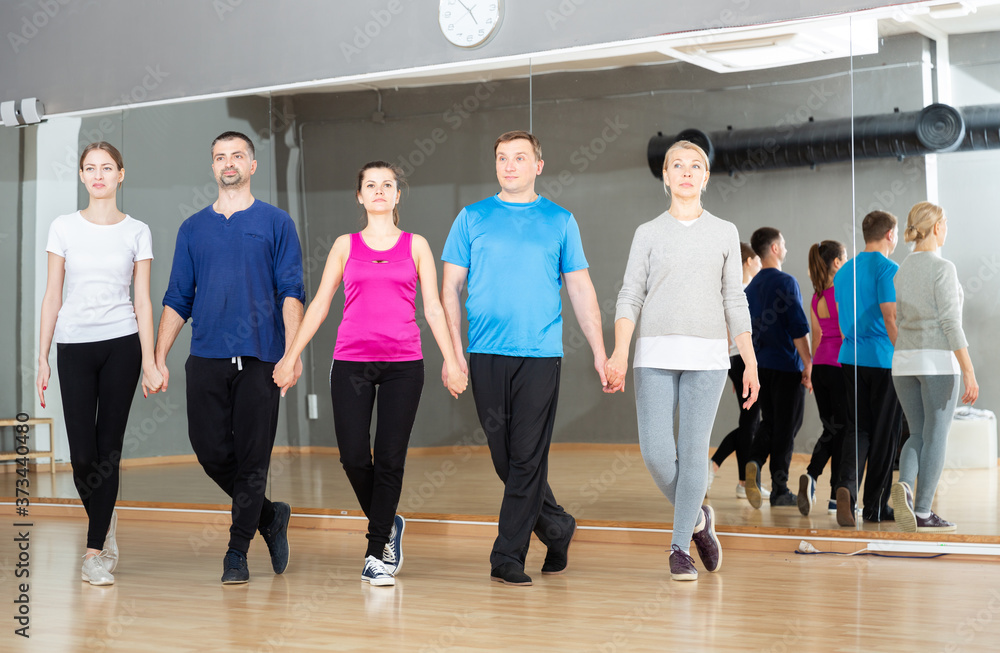 Group of adult people practicing celtic dances in dance class