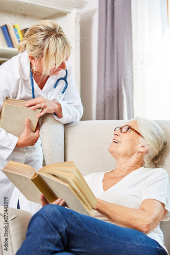 Female doctor and senior woman talking over books © Robert Kneschke