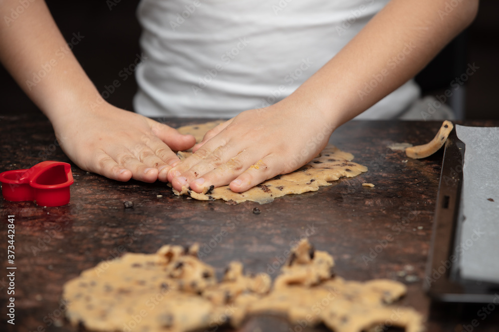 Kids baking cookies in house kitchen . Close-up child`s hands preparing cookies using cookie. Kids baking cookies in house kitchen . Close-up child`s hands preparing cookies using cookie.