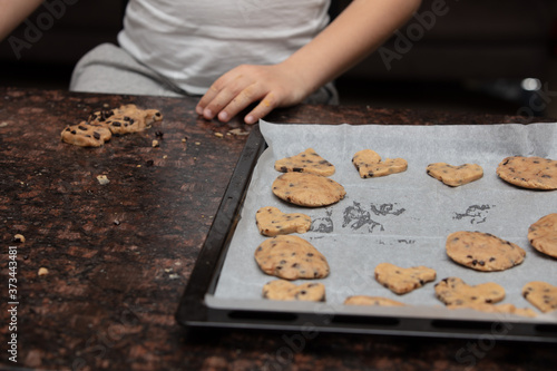 Kids baking cookies in house kitchen . Close-up child`s hands preparing cookies using cookie.