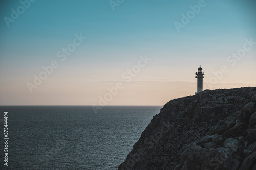 Lighthouse on a cliff on a sunset