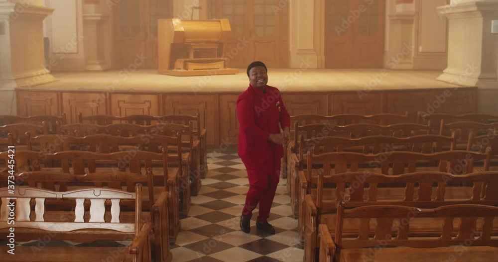 Front view of male musician wearing red suit dancing while singing song ...
