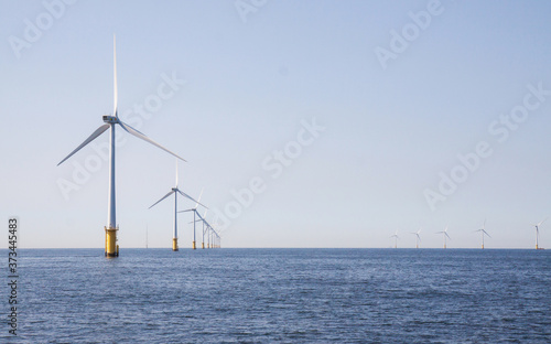 Wind turbines in an offshore wind farm in the North Sea just off the coast of the Netherlands, on a clear day.