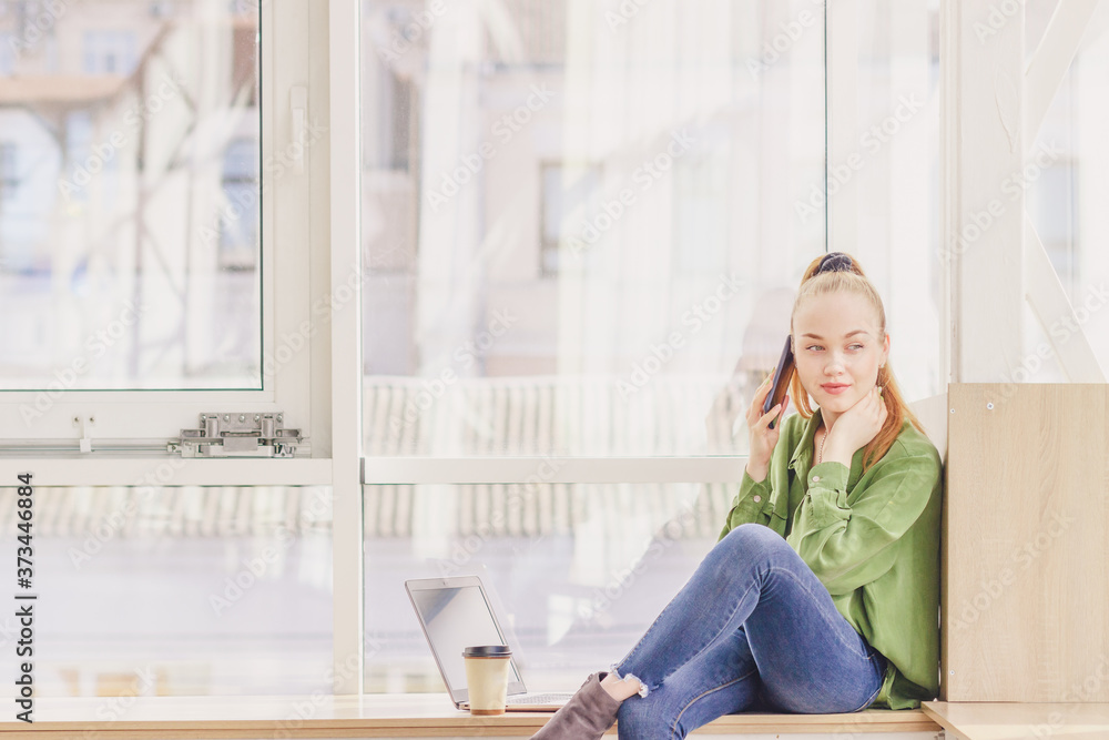 Young beautiful woman sits with a smartphone Young beautiful woman sits with a smartphone