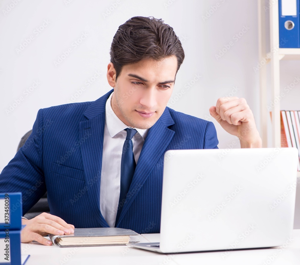 Young handsome businessman employee working in office at desk Young handsome businessman employee working in office at desk