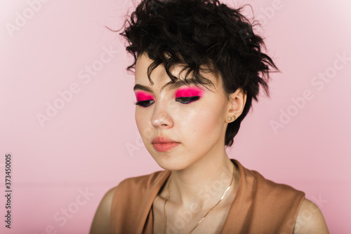 Portrait of a beautiful model with bright pink make-up and flying hair