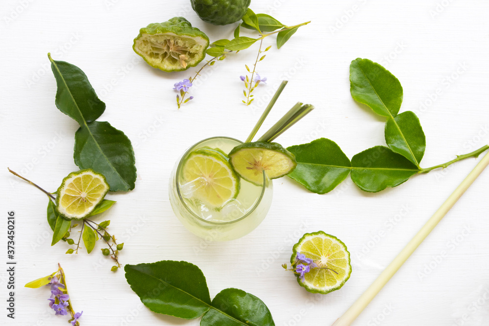 herbal healthy drinks iced kaffir lime cocktail water with bergamot slice local flora of asia arrangement flat lay style on background white - obrazy, fototapety, plakaty 