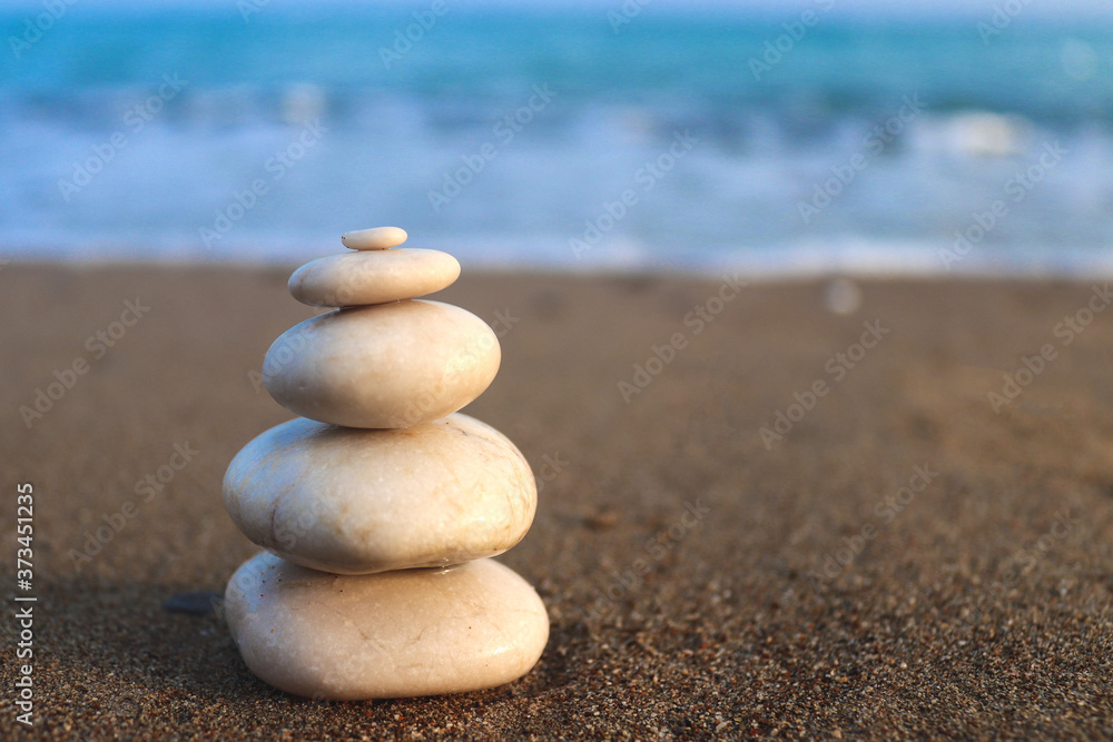 Fototapeta premium Zen stones. Concept of harmony, stability, life balance, relaxation and meditation. Pyramid of stones on the seashore. Copy space for text, selective focus, blurred