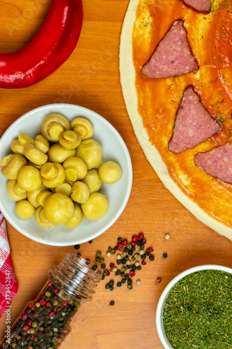 Pizza dough with tomato sauce on a rustic table