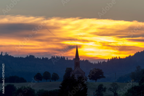 Sunset over the village Hofen in the Black Forest with the silhouette of the church