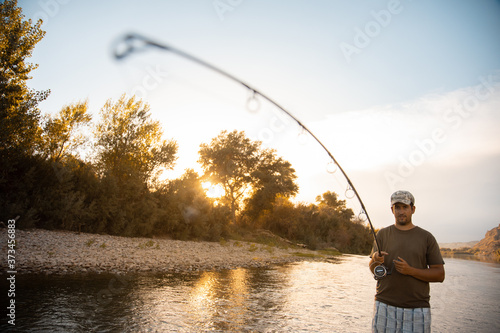river fisherman with fishing rod © robcartorres