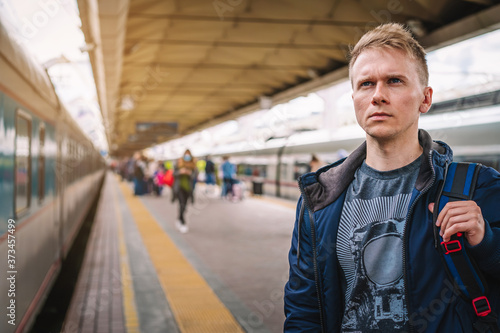 Moscow / Russia - 15 Aug 2020: A young man with a backpack is standing on the platform at the railway station waiting to Board the train