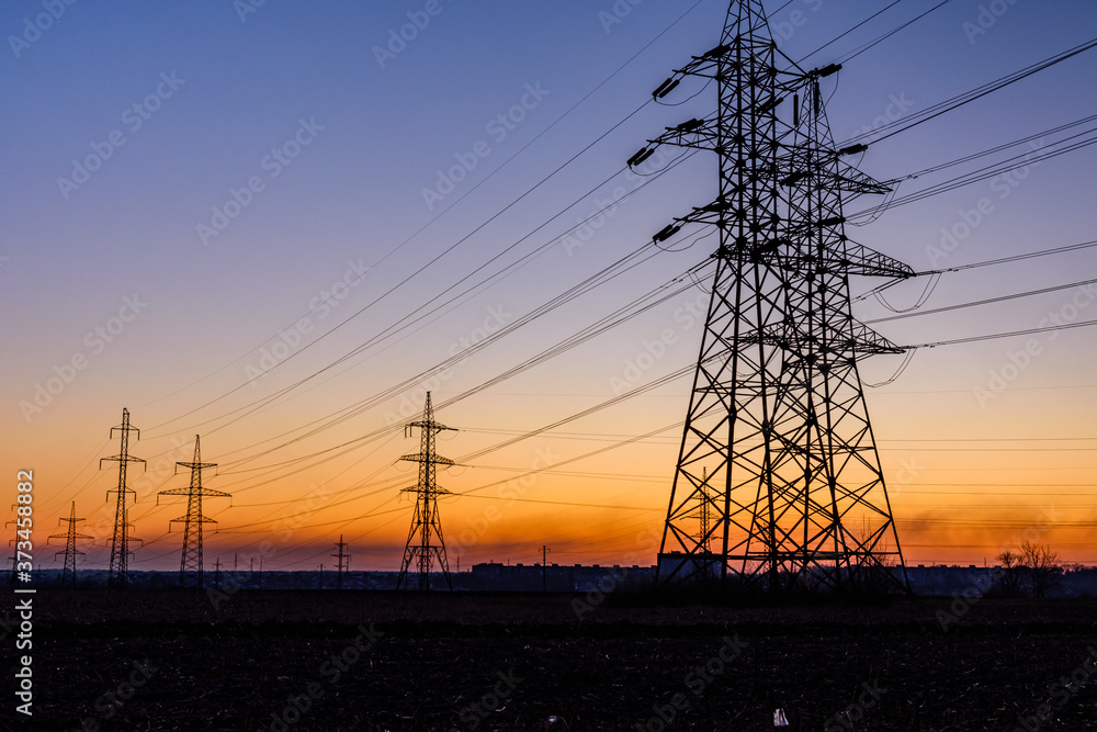 Fototapeta premium High voltage power line in a field at sunset