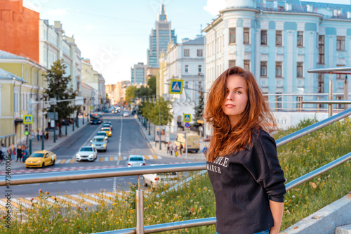 Moscow / Russia - 15 Aug 2020: Portrait of a charming girl with the background of Moscow streets with high-rises and shops