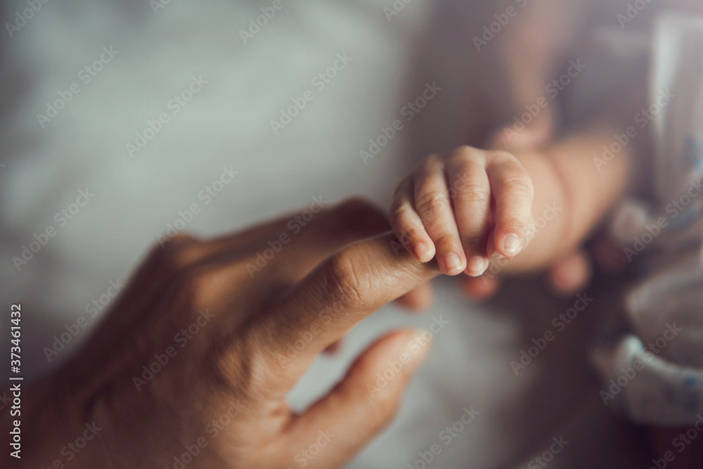 Newborn baby holding mother's hand. - obrazy, fototapety, plakaty 