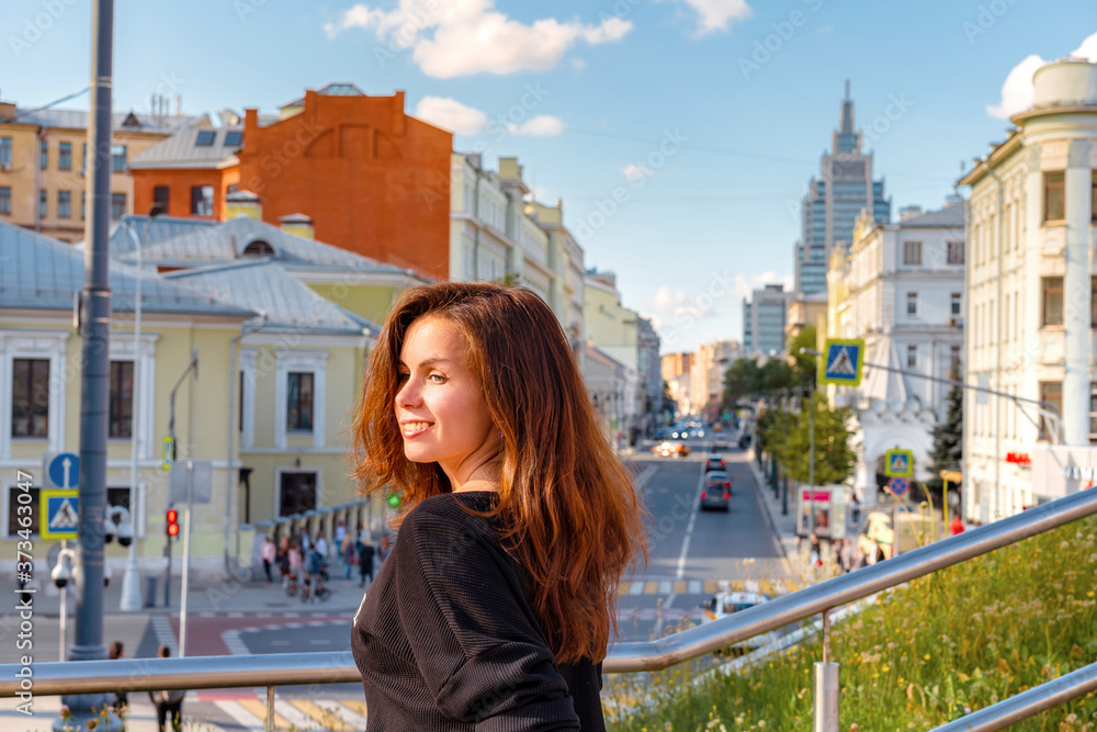 Moscow / Russia - 15 Aug 2020:  Portrait of a charming girl with the background of Moscow streets with high-rises and shops