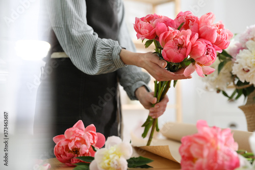 Florist with beautiful peony bouquet indoors, closeup