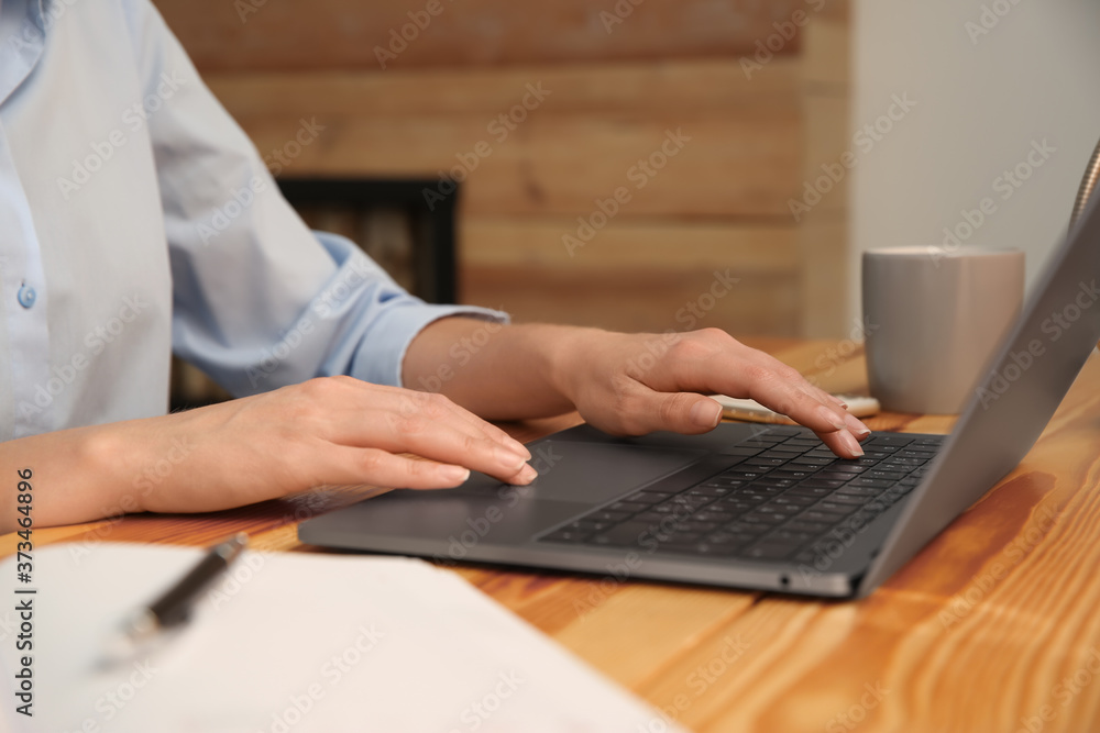Woman working with modern laptop at wooden table, closeup Woman working with modern laptop at wooden table, closeup