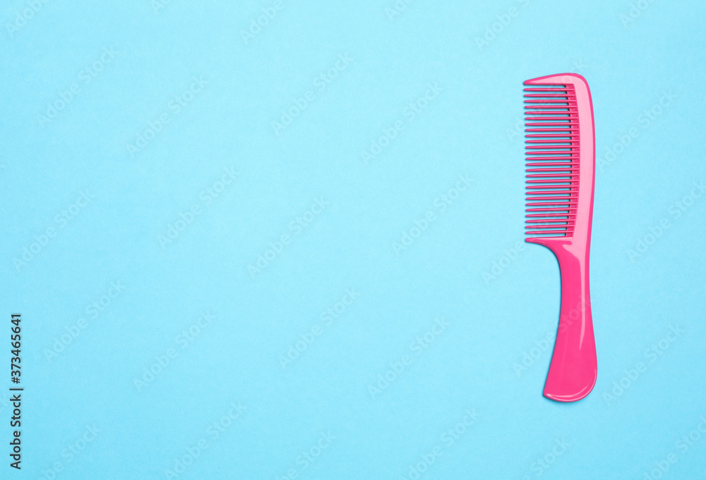 Modern pink hair comb on light blue background, top view. Space for text Modern pink hair comb on light blue background, top view. Space for text