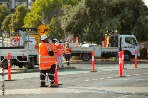 Melbourne, Victoria / Australia - January 2 2020: Traffic control worker is holding stop sign to stop the traffic near Caulfield train station.