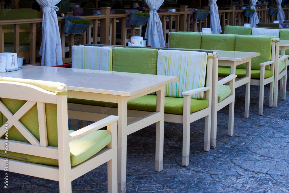 Summer terrace veranda of a cafe. Cozy green wooden chairs and tables