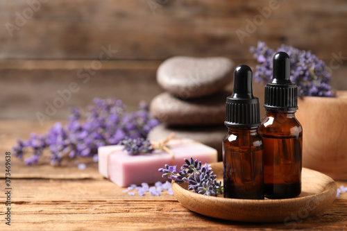 Cosmetic products and lavender flowers on wooden table. Space for text