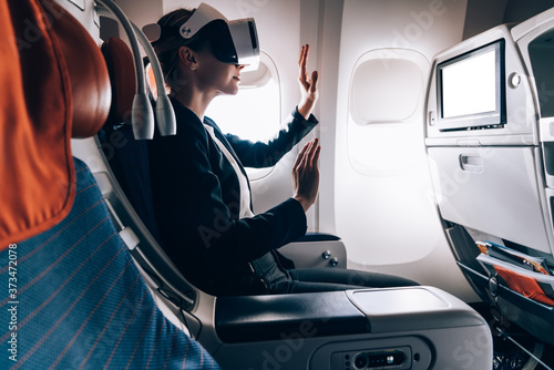 Thrilled woman wearing VR headset in airplane