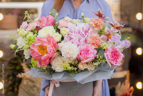 Bouquet in box. Gift box with beautiful flower. Woman holding big beautiful blossoming box bouquet of fresh roses, carnation, peonies, eustoma and others.