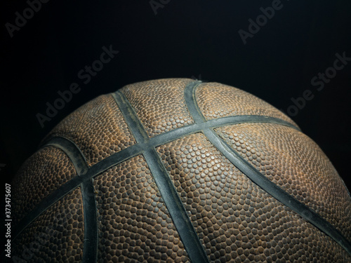 Sports props, close up of basketball ball against a dark background