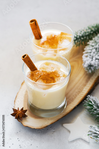 Eggnog cocktail, creamy christmas drink with spice cinnnamon on white background