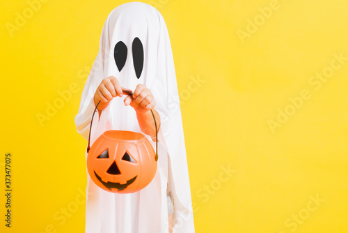 Fotografia Funny Halloween Kid Concept, little cute child with white dressed costume hallow