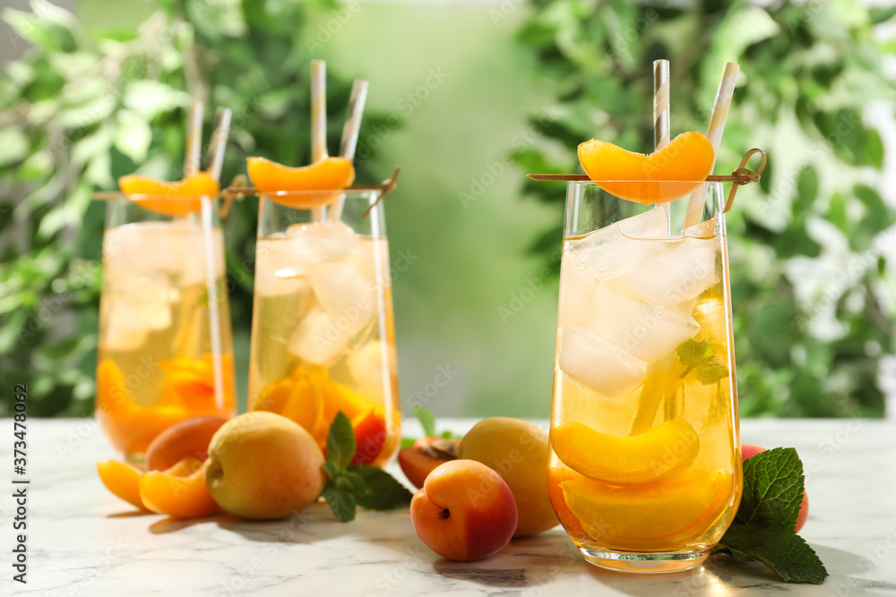 Fototapeta premium Delicious refreshing drink with apricot on white marble table