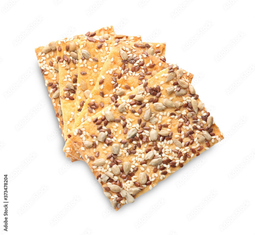 Stack of delicious crispy crackers with sunflower, flax and sesame seeds on white background, top view