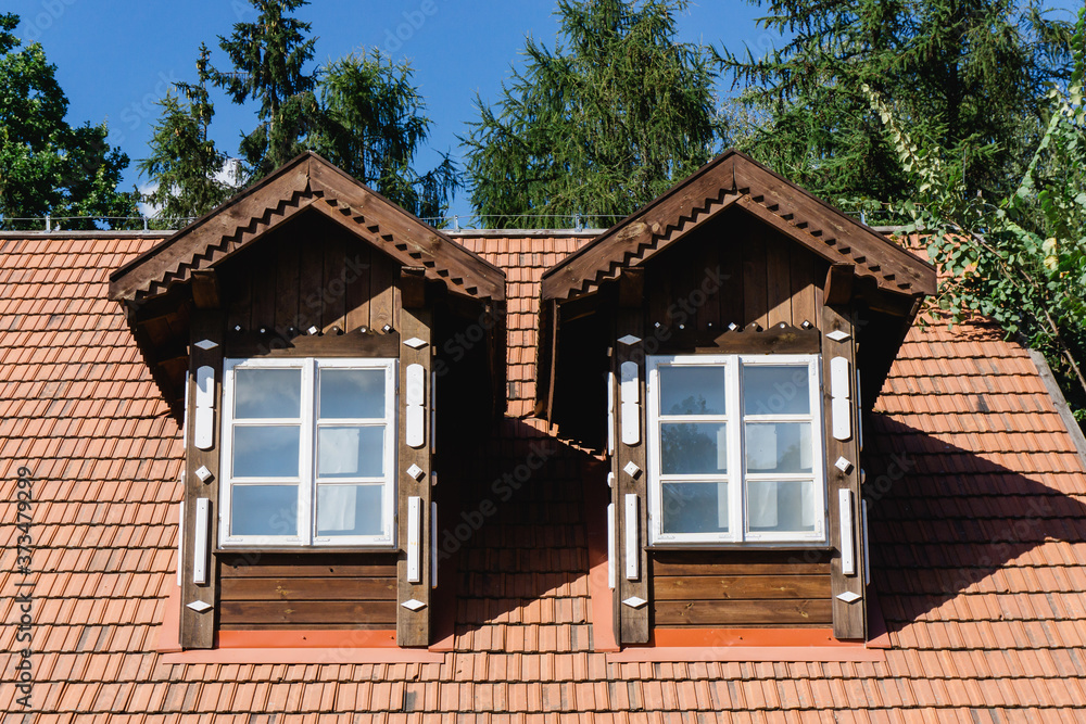 Tiled roof attic. Cottage house rooftop window. Wooden village countryside architecture.