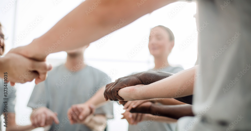 Fototapeta premium background image is a group of people holding each other's hands.