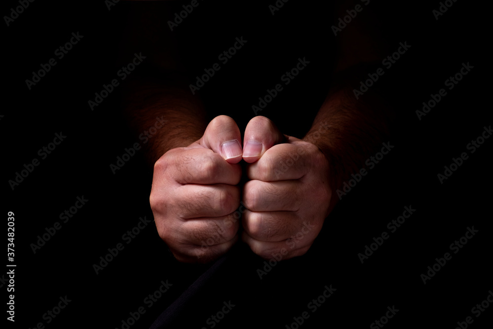 Male hands emerging from the darkness. Hands on a black background. Male hands emerging from the darkness. Hands on a black background.